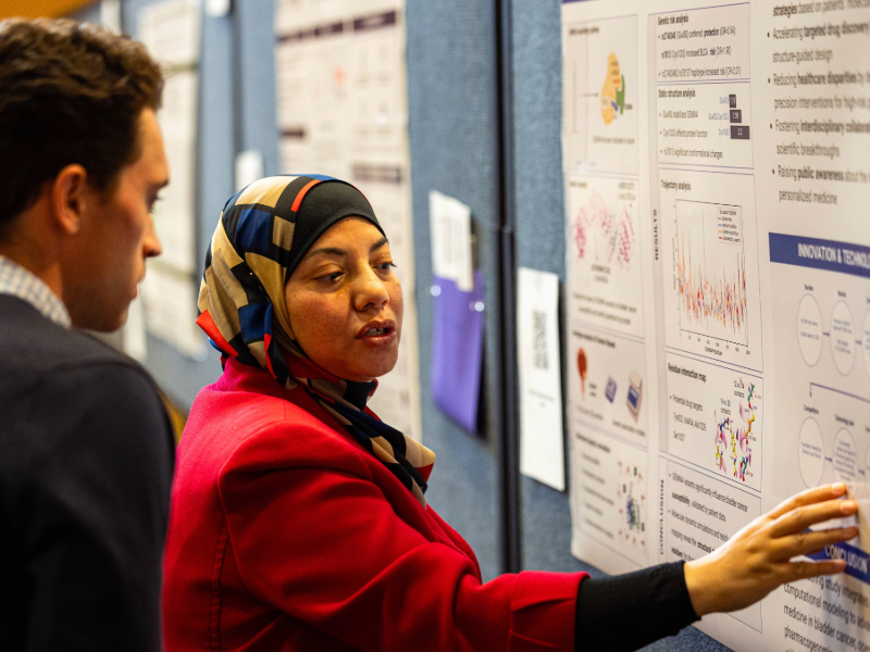 This is a photo of Dr. Eman Toraih presenting a research poster