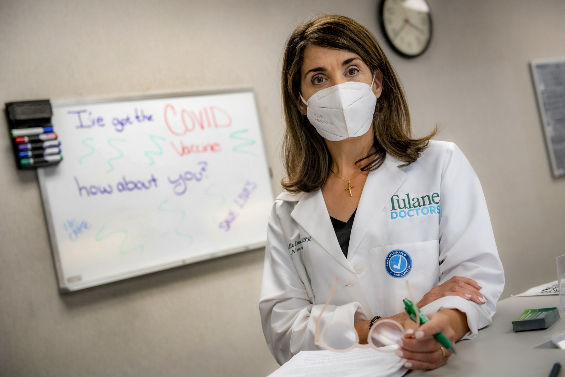 This shows a female doctor wearing a mask in front of a white board