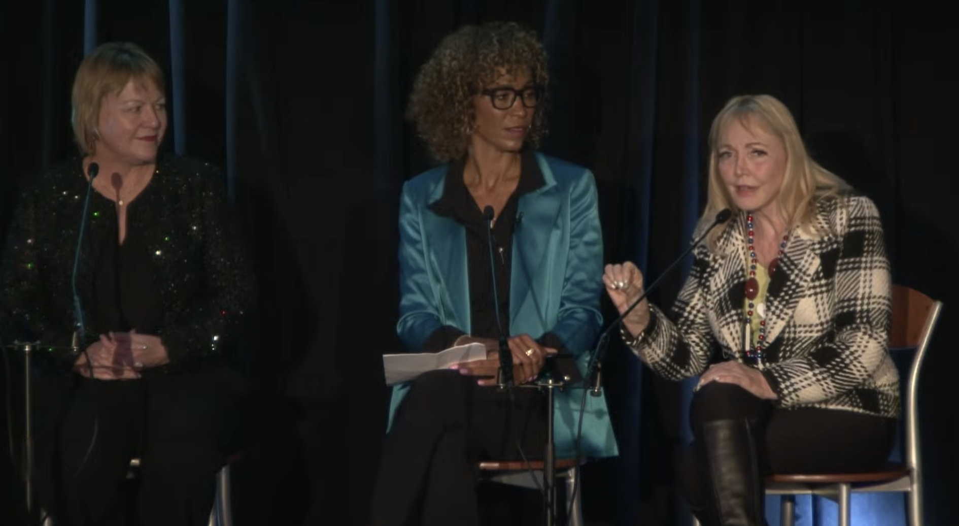 Three women sitting on a panel 