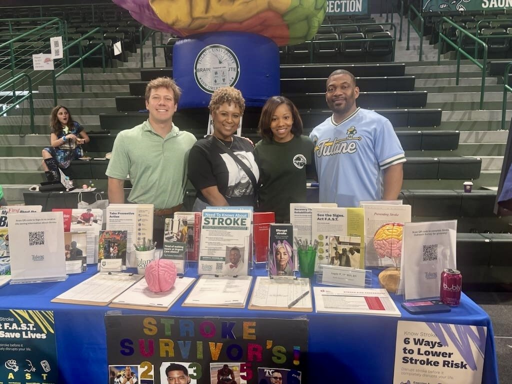 A group of people stand at a table with information about strokes