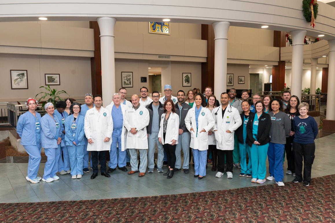 A group of medical personnel stand in the lobby of a hospital