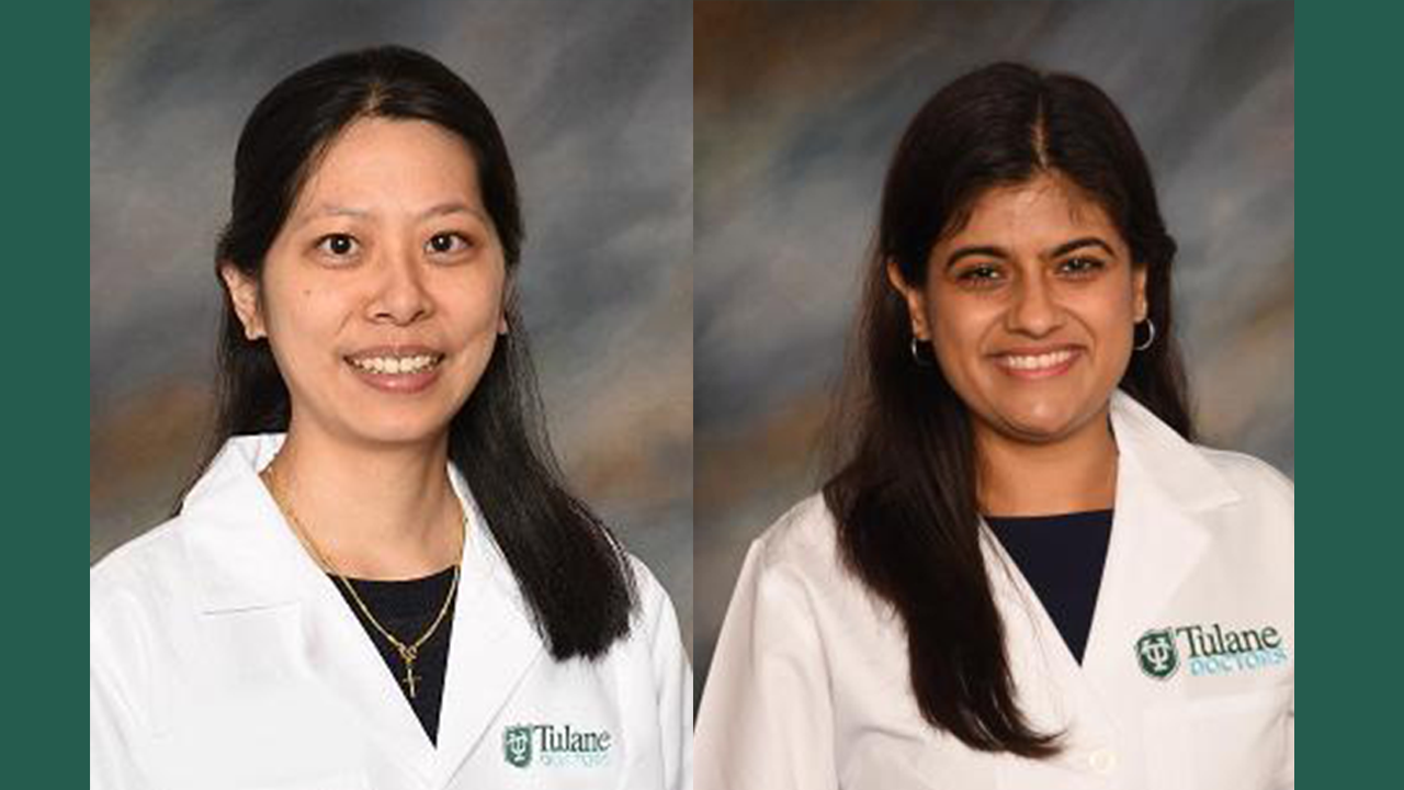 Two smiling female medical professionals in white Tulane University lab coats.