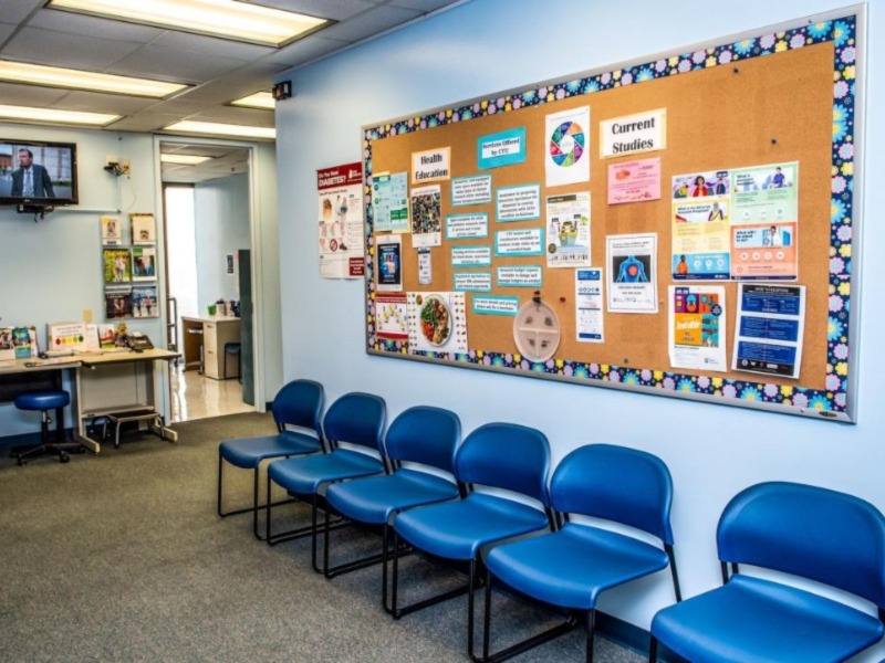 This image shows a clinic waiting room with a bulletin board featuring information about current studies.