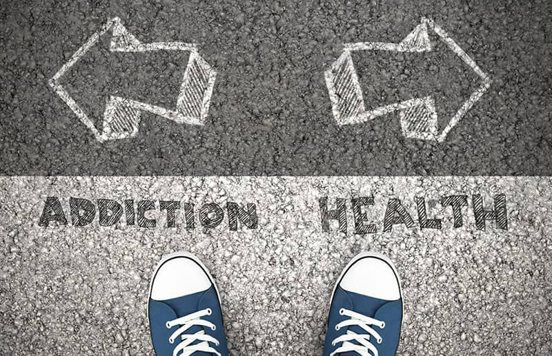 Addiction vs. Health sign with arrows pointing in opposite directions