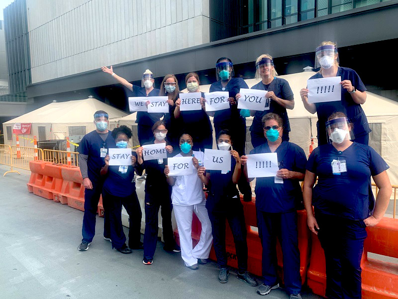 group of nurses & doctors outside hospital working during COVID-19 pandemic