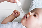 Baby takes medicine with a dropper