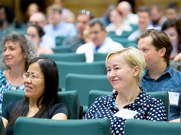 faculty members sit in auditorium chairs and listen to a professional development seminar