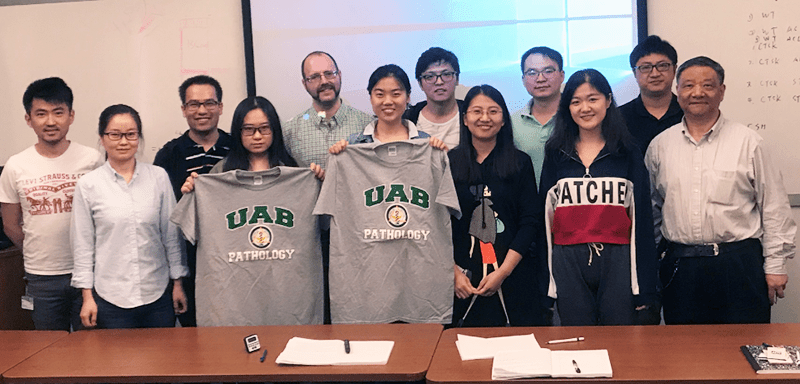group standing together holding UAB pathology shirts