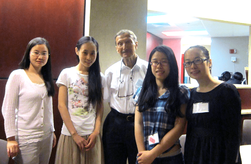 small group of females standing with professor