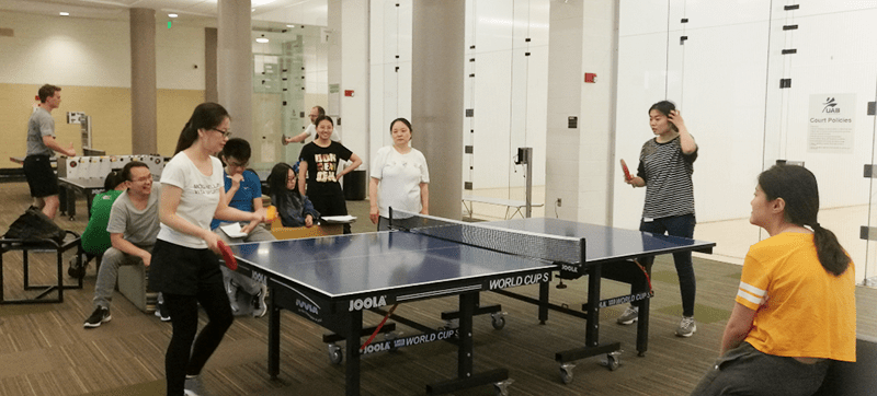 student watch as other students play ping pong