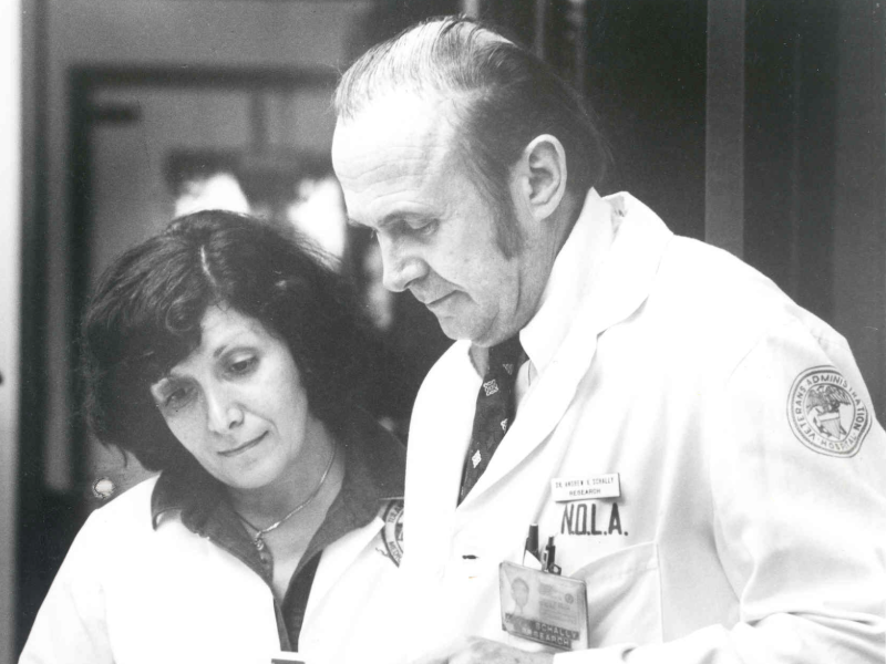 This is a black and white photo of two researchers talking