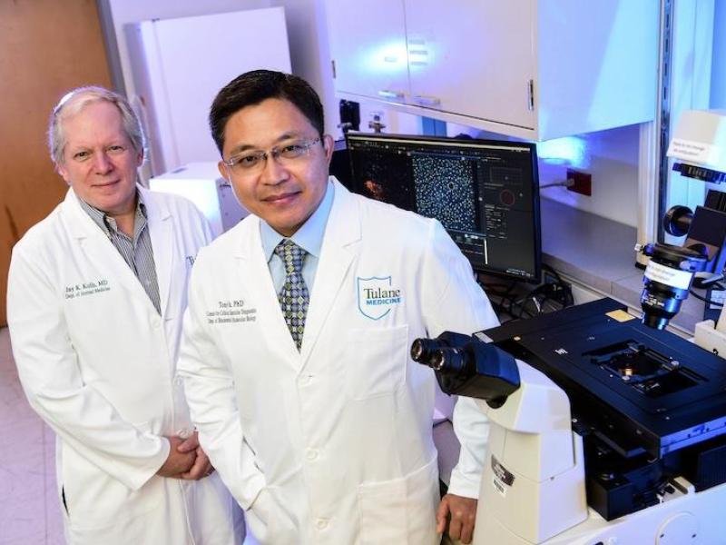 A photo of two people standing in a lab wearing white coats