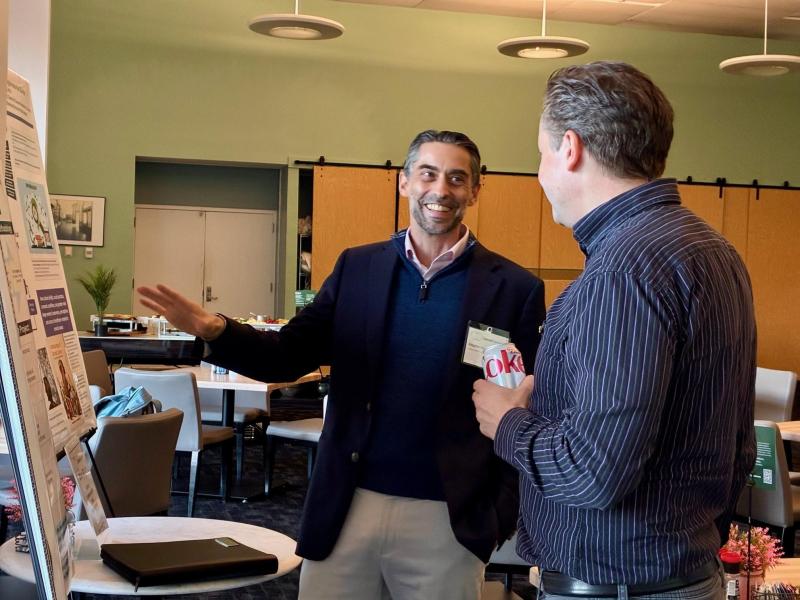 Stephen Ostertag and Loren Gragert discuss a research board