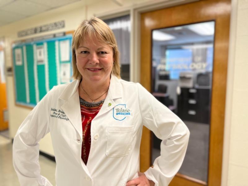 This image shows a woman in a white lab coat.