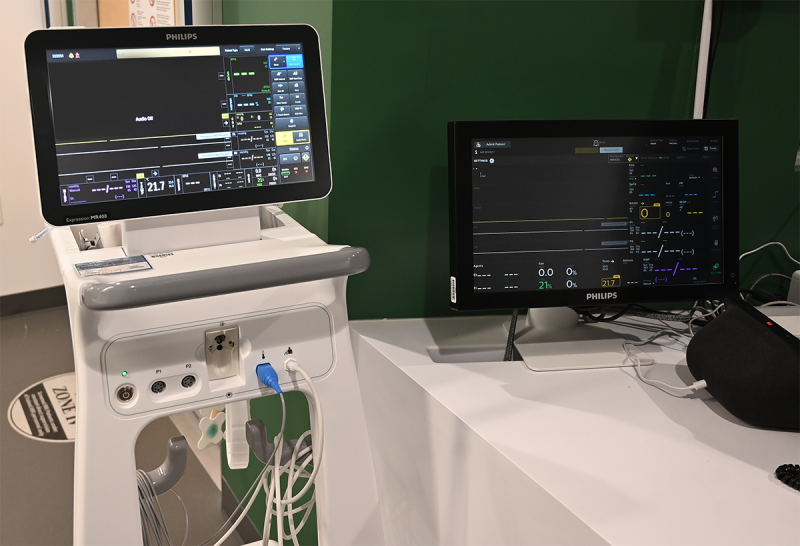 Two screens one of which is on a mobile stand, both used to monitor patient vital signs