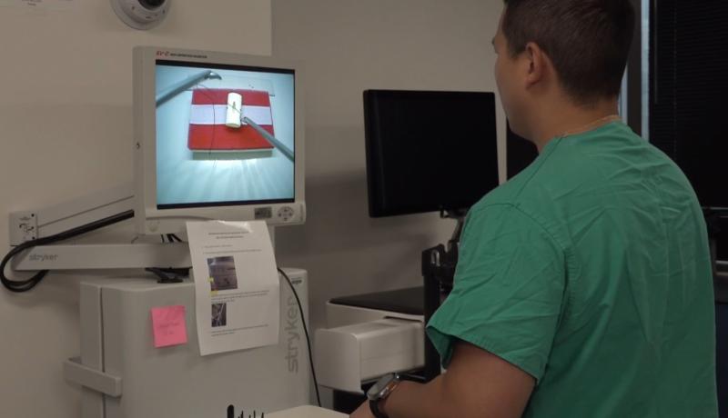 a surgery resident practices on a simulation device