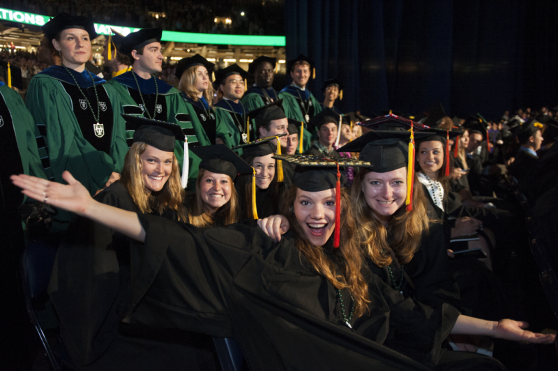Graduation students with arms widespread and smiling
