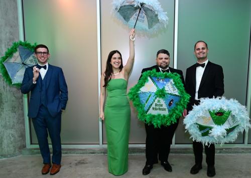 four nicely people in formal wear holding parisols