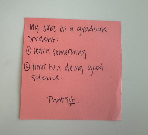 Post-it Note pink post-it note that reads "my job as a graduate student 1) learn something 2) have fun doing good science, that's it