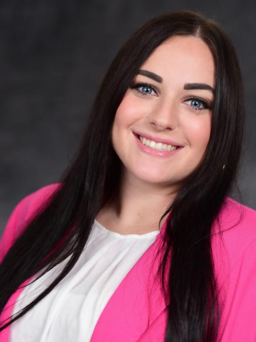 Caroline Rhodes in a white shirt and bright pink blazer