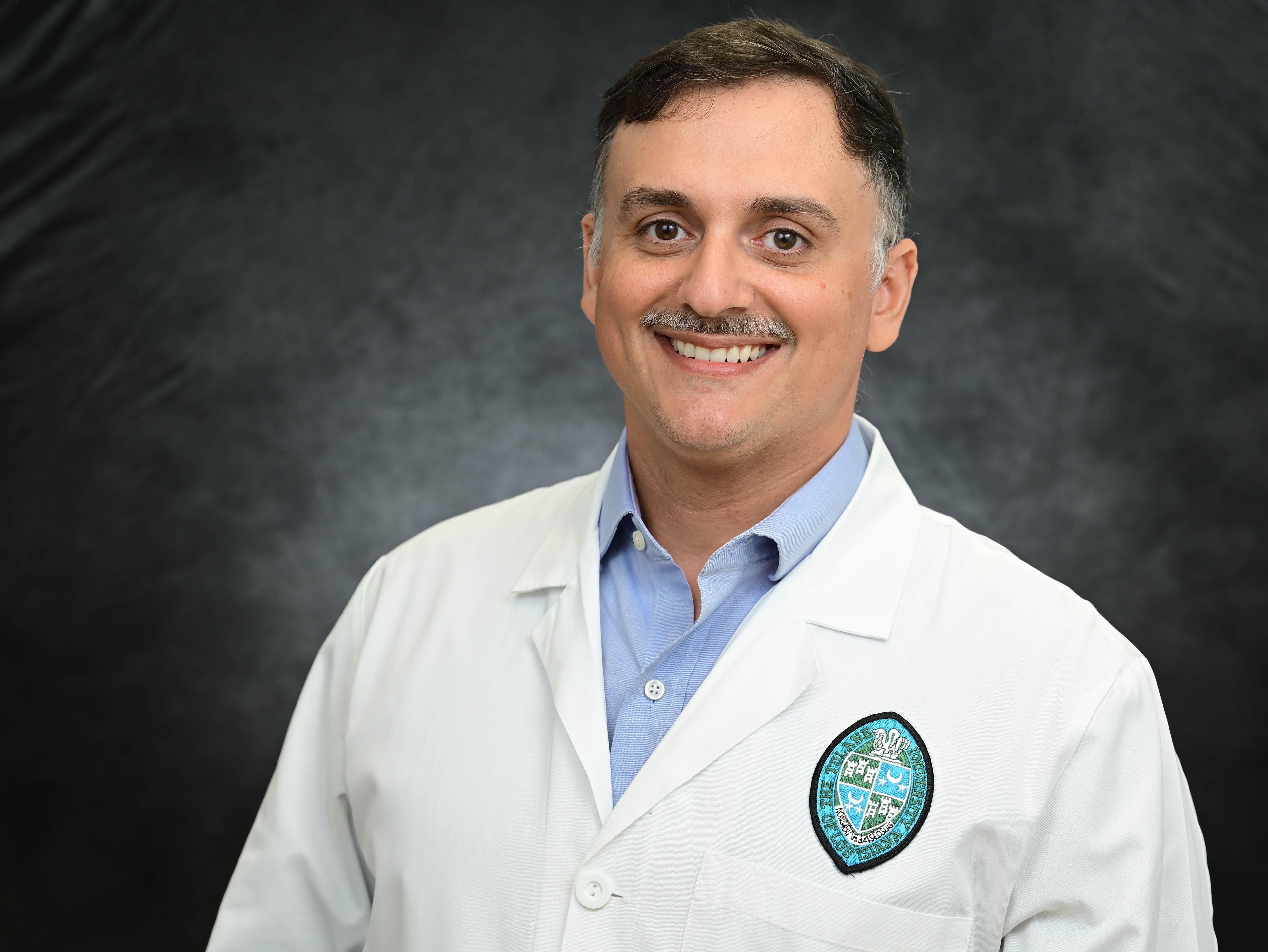 Photo depicts Jacob Bitoun, a smiling caucasian man wearing a white lab coat