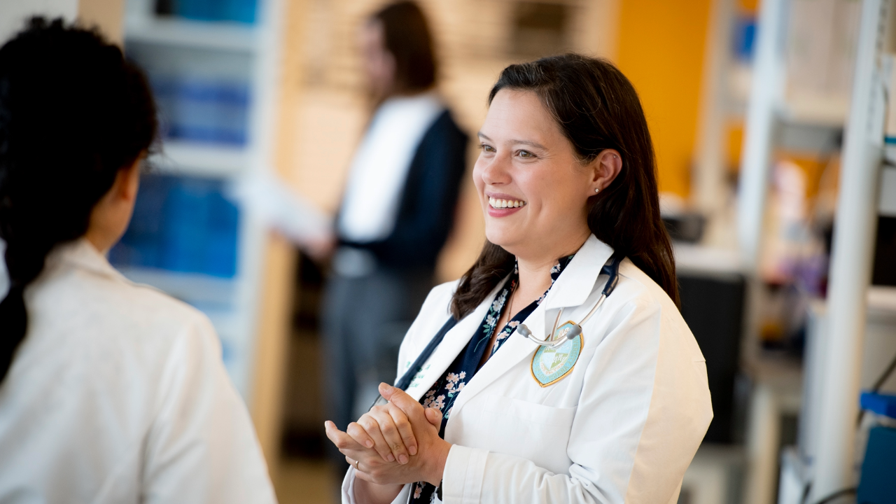 This is a photo of a physician in a white coat talking to another physician