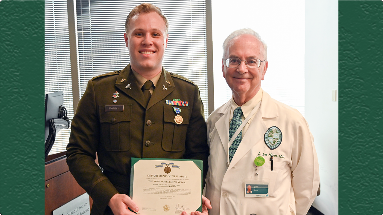 This is an image of a student in an Army uniform standing next to a physician in a white doctor's coat