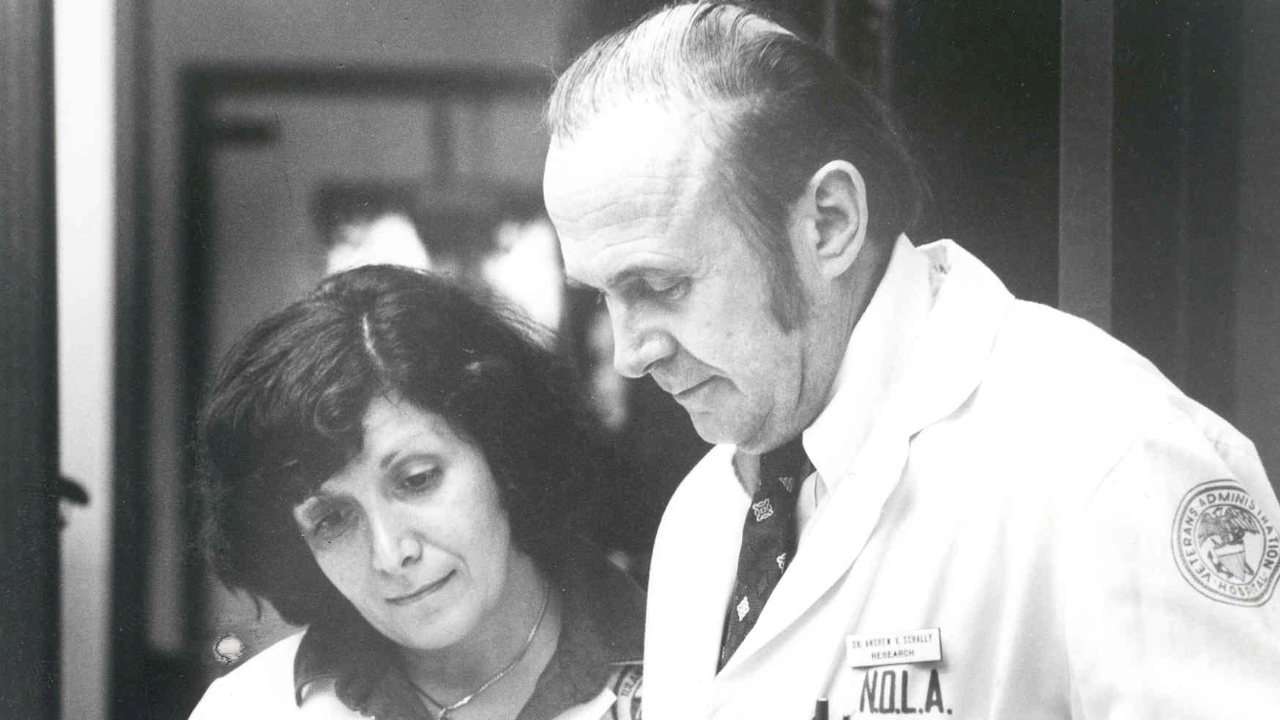 This is a black and white photo of two researchers in a lab