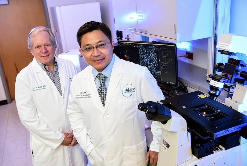 A photo of two people standing in a lab wearing white coats