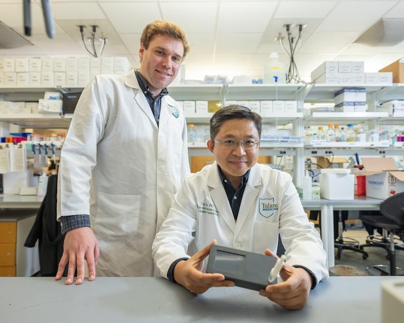 Tony Hu and Brady Youngquist with handheld tuberculosis testing device 