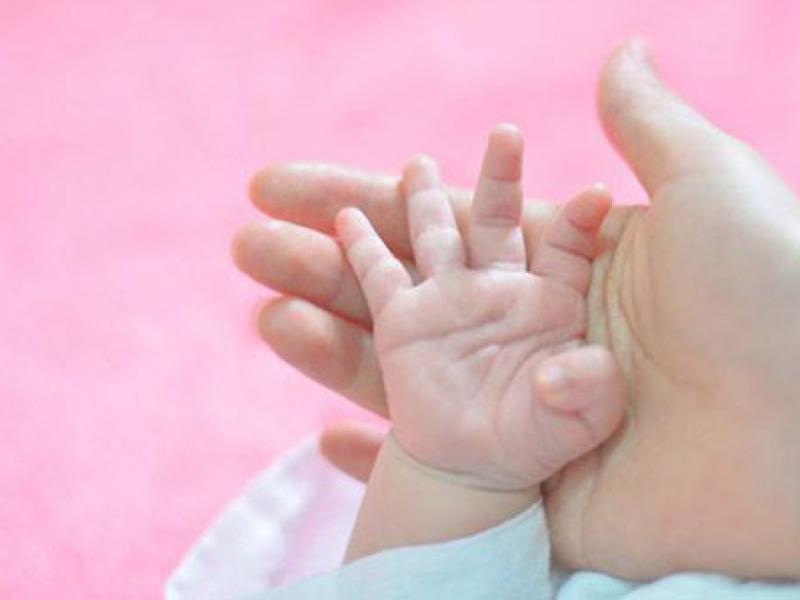 baby's hand against mother's palm
