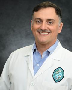 Photo depicts Jacob Bitoun, a smiling caucasian man wearing a white lab coat