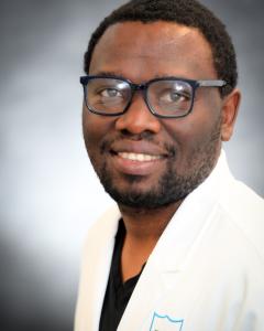 head shot photo of Ulrich Femoe Member looking up and to the right and smiling