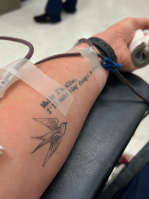 An arm with a needle drawing blood 