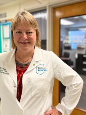 This image shows a woman in a white lab coat.